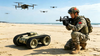 Soldier with military equipment on a beach with drones in the background